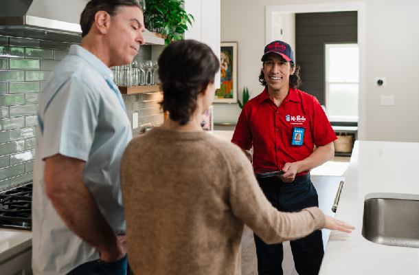 Mr. Rooter professional speaking with customers inside their home.