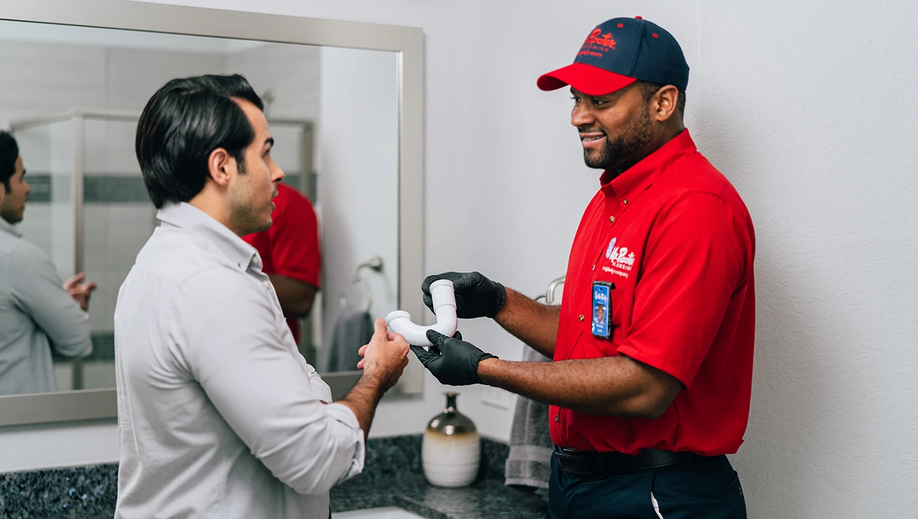 Mr. Rooter technician showing a customer a pipe.