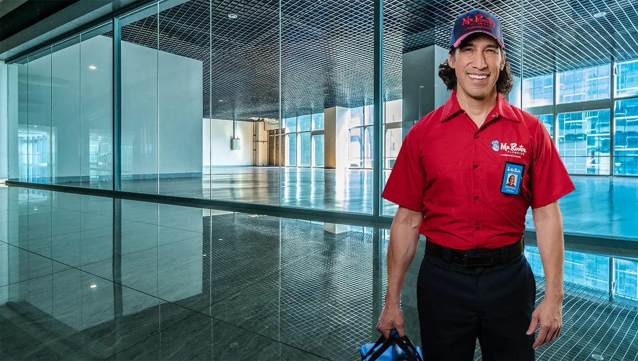 Mr. Rooter technician standing in a commercial building.