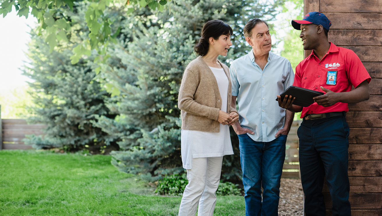 Mr. Rooter professional speaking with customers outside of their rural home.