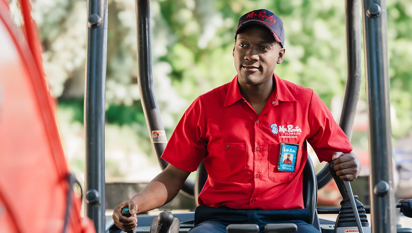 Mr. Rooter technician driving machinery.