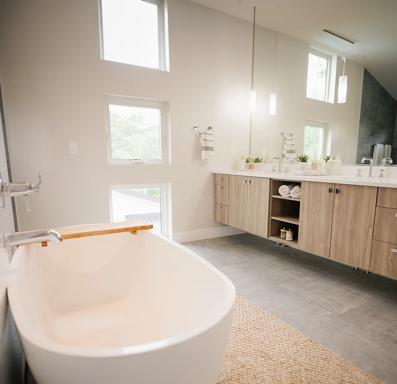 Image of a modern bathroom with a soaking tub and floor to ceiling windows.