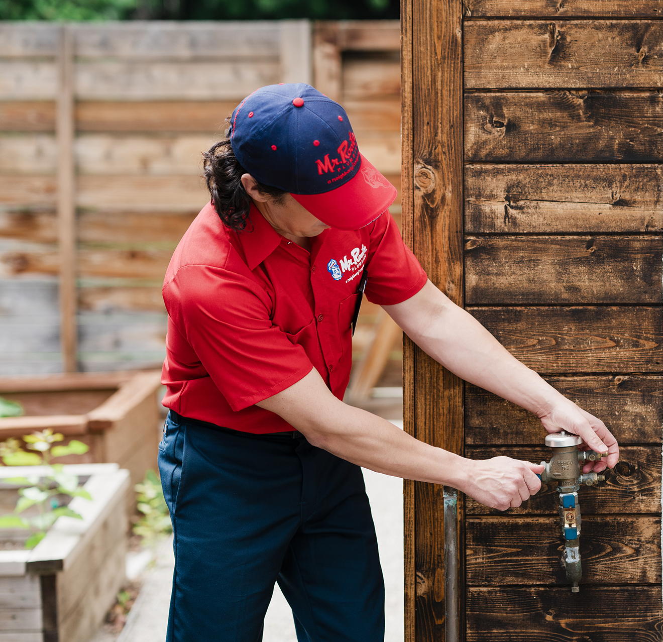 Mr. Rooter technician repairing outdoor water source.