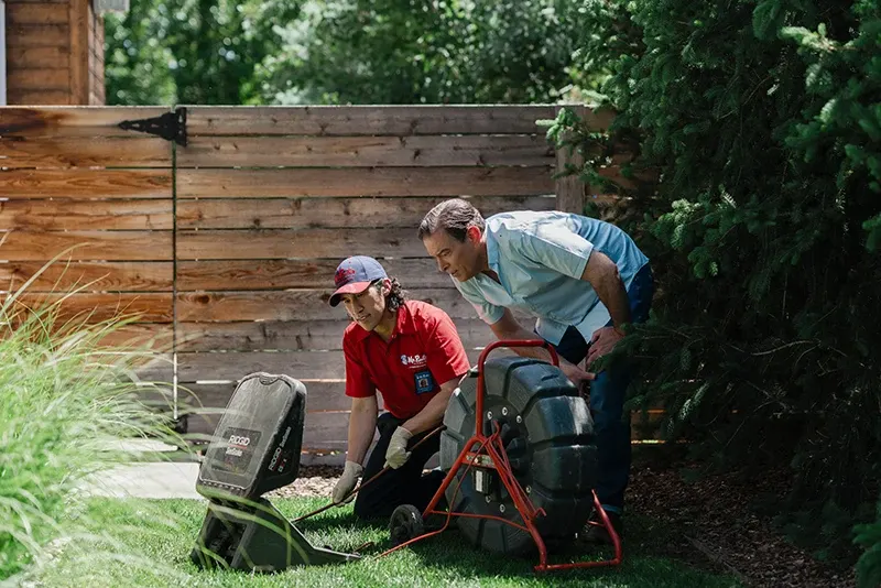 Mr. Rooter plumber showing a customer his findings during a sewer camera inspection service
