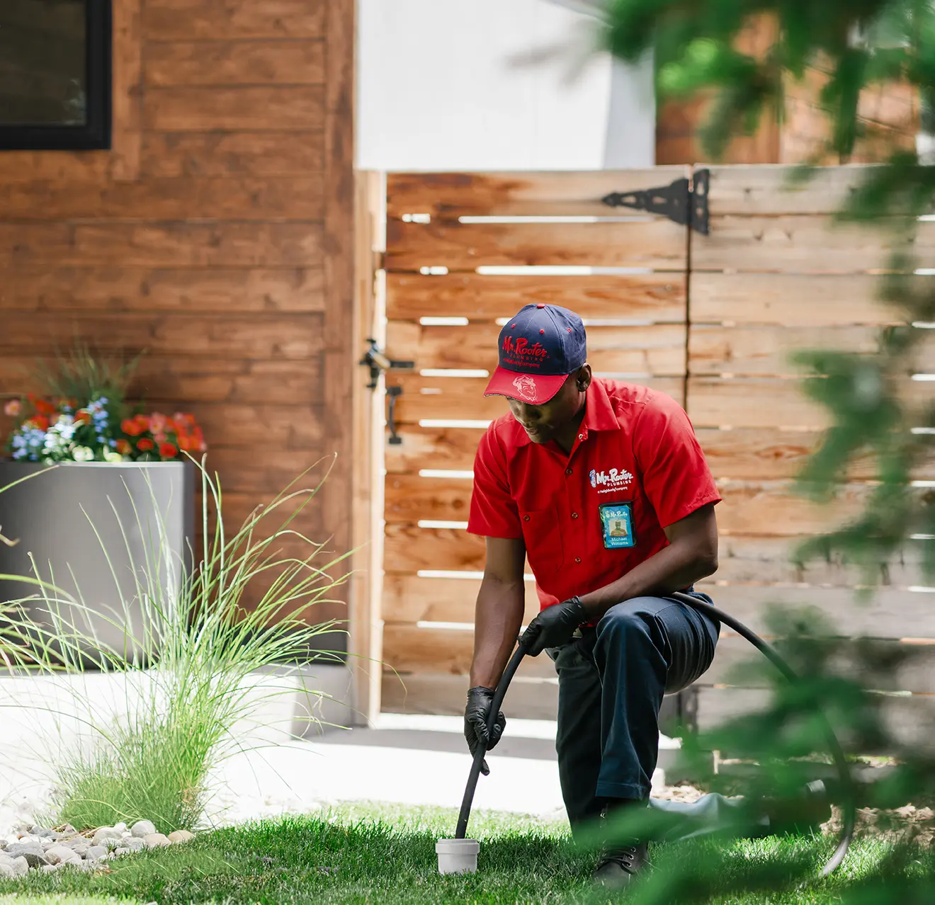 Mr. Rooter technician cleaning a sewer on the exterior of a home.