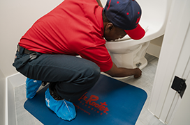 Mr. Rooter technician fixing a toilet.