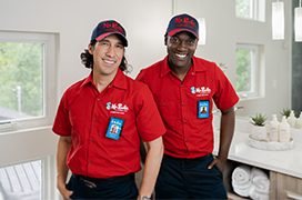 Portrait of two Mr. Rooter technicians standing in a bathroom.