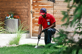 Two customers speaking with a Mr. Rooter technician outside of their home.