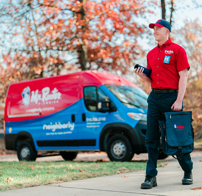 Mr. Rooter plumber walking in front of a Mr. Rooter van.