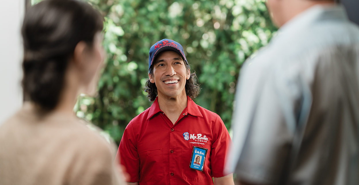 Mr. Rooter technician greeting customers at their door.