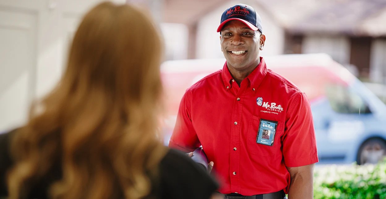 Customer greeting a Mr. Rooter technician at her front door.