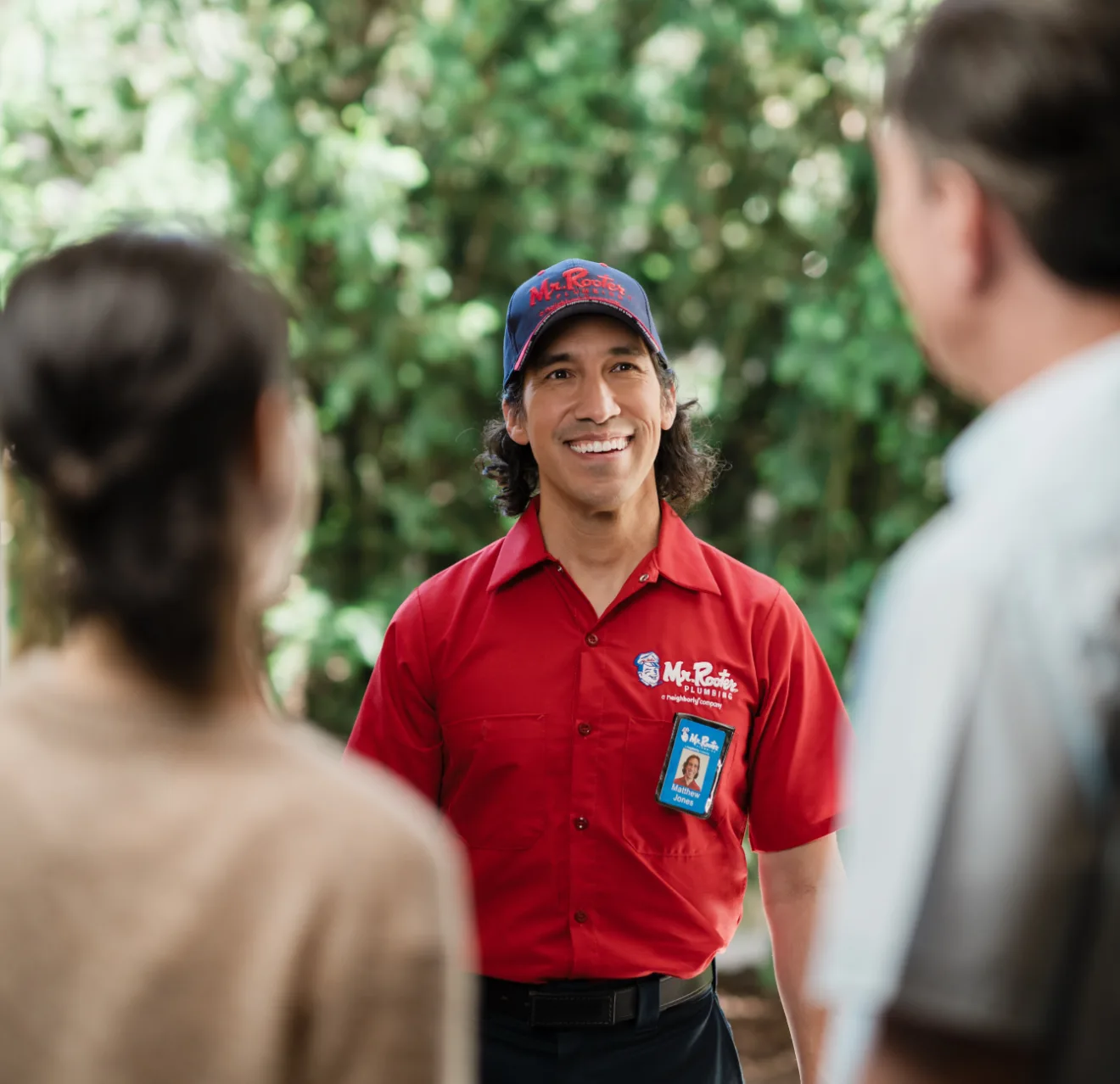 Mr. Rooter technician greeting customers at their door.