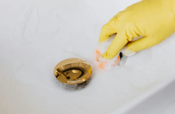 Person cleaning a sink drain.