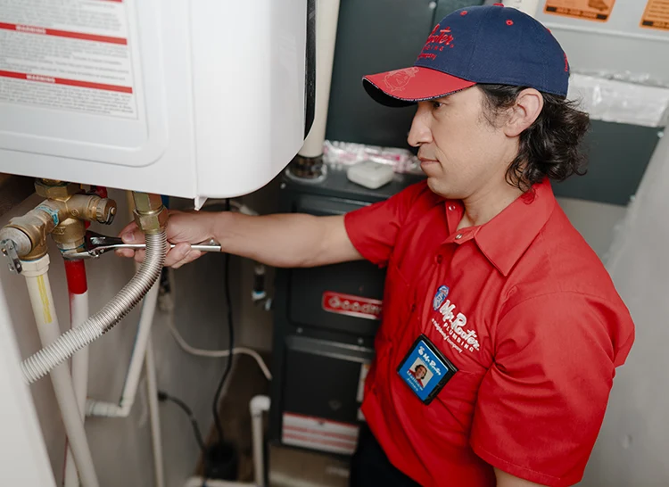 Mr. Rooter plumber installing a tankless water heater.
