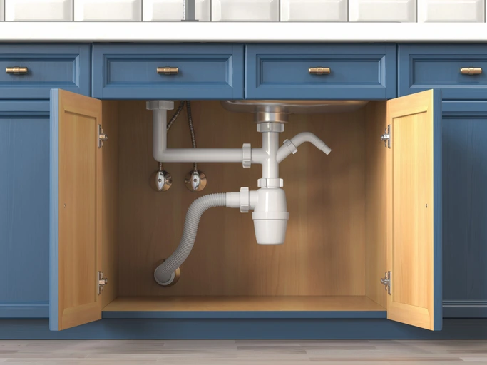 Under-sink plumbing in a residential kitchen.