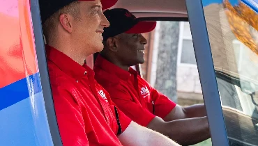 Two plumbers from Mr. Rooter Plumbing in a truck.