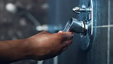 A plumber getting ready to remove a shower faucet cartridge.