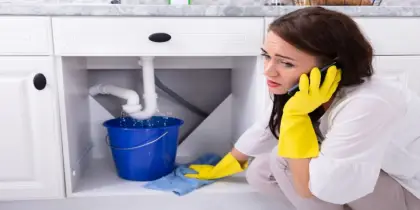 A person investigating plumbing problems in a home