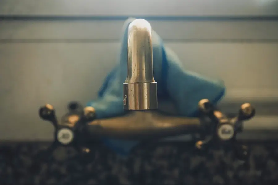 Close-up of a vintage brass faucet with a blue cloth draped in the background.