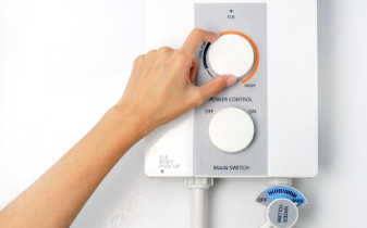 Hand adjusting temperature setting on tankless water heater