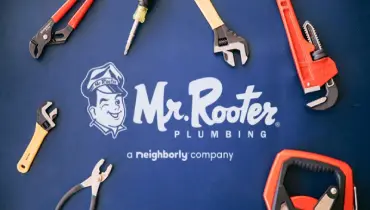 Mr. Rooter Plumbing a Neighborly Company banner with tools and a blue background.